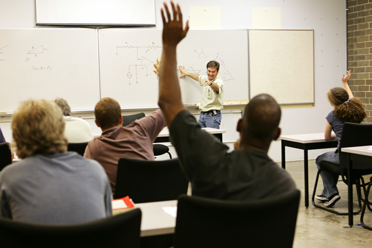 Adult professional raising hand to solve problem in classroom