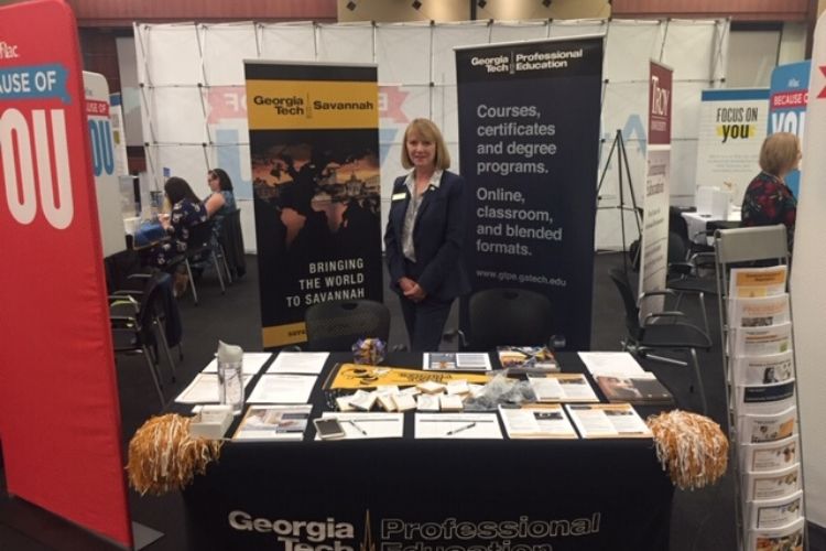 Theresa Atkins standing being the Georgia Tech booth