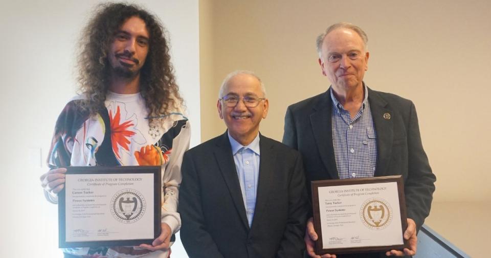 Carson and Terry Tucker with their Power Systems Certificates standing with Professor Sakis