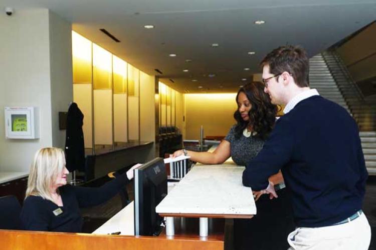 Two attendees at concierge desk receiving help