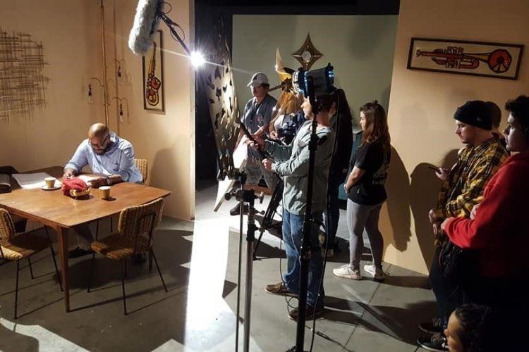 Group of film studios record actor sitting a kitchen table