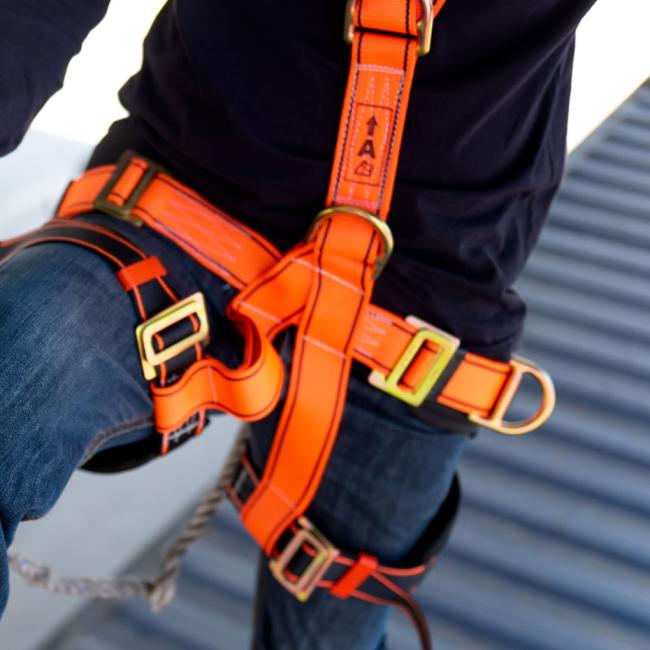 Construction worker using safety harness and safety line on a construction site project
